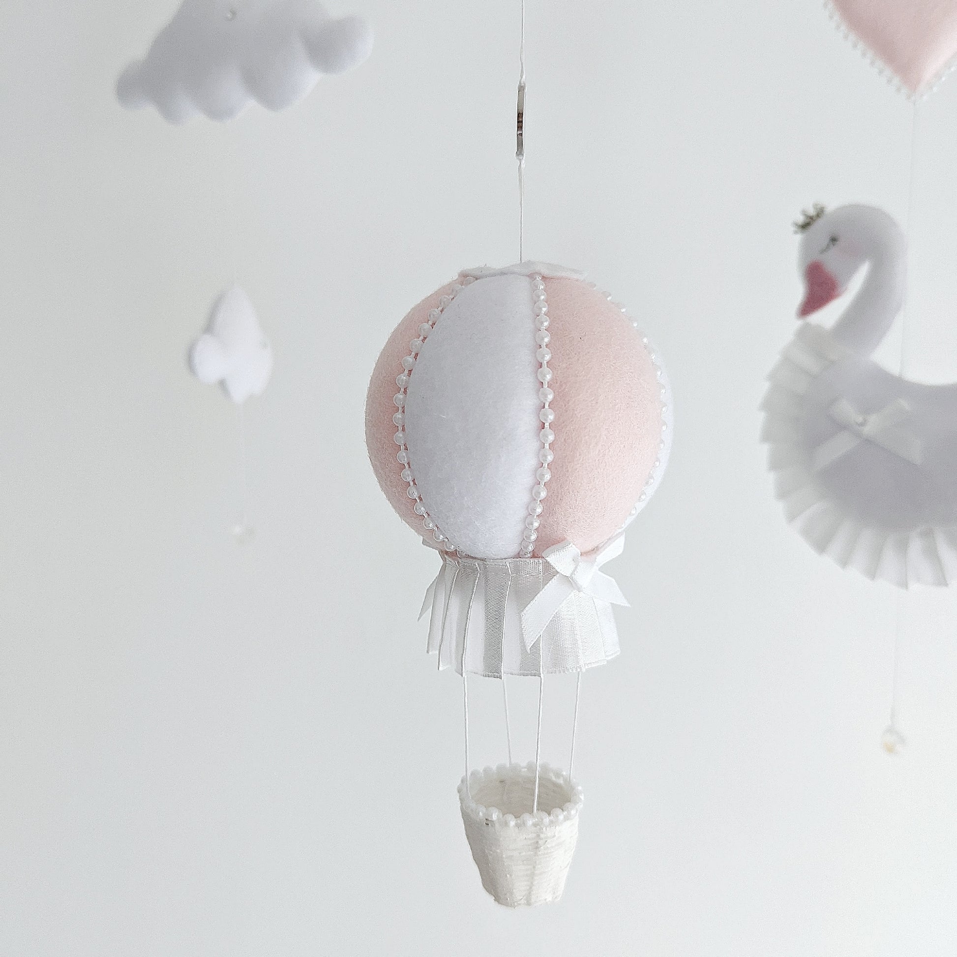 Keepsake baby girl mobile with swans, crystal drops, and a soft white and pink hot air balloon.