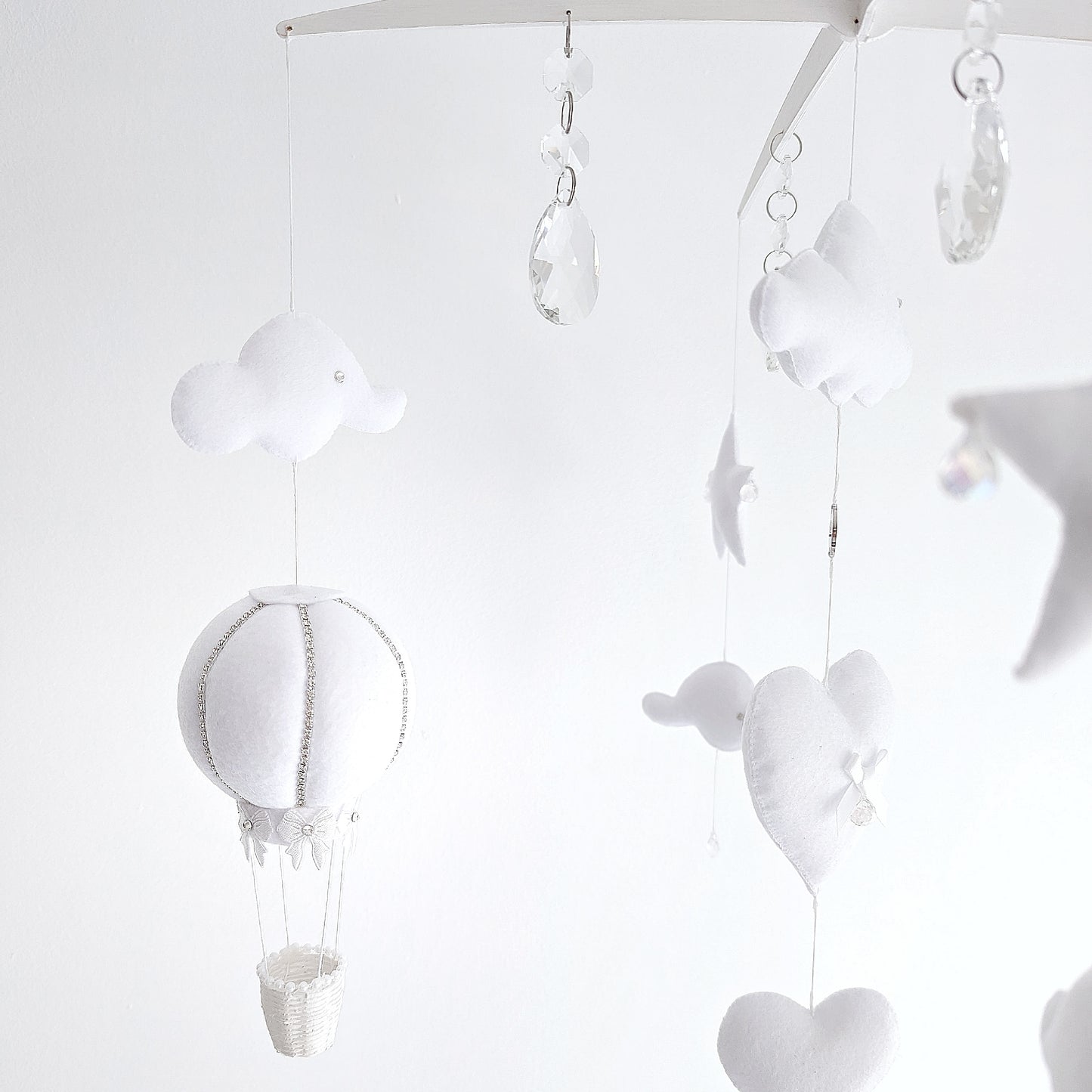 Luxury baby mobile with soft clouds, sparkling crystal drops, and felt hot air balloons floating in harmony.