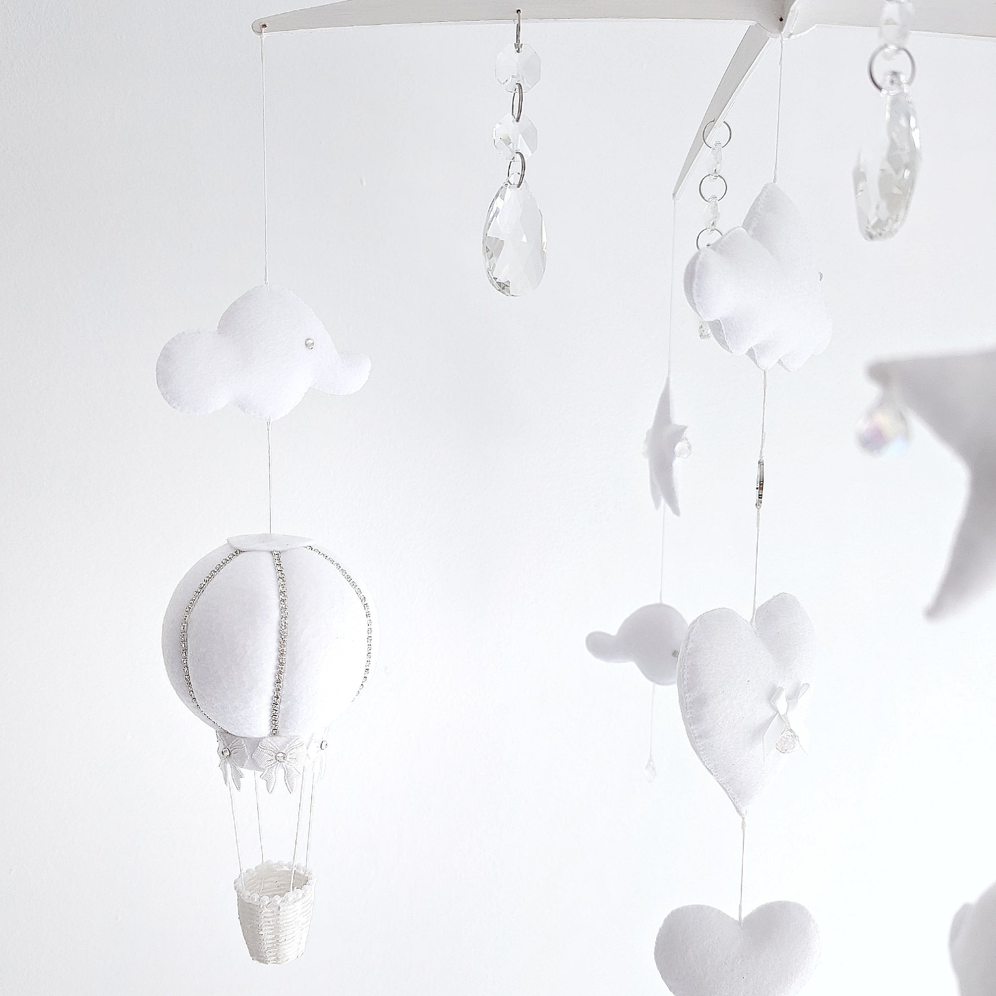 Luxury baby mobile with soft clouds, sparkling crystal drops, and felt hot air balloons floating in harmony.