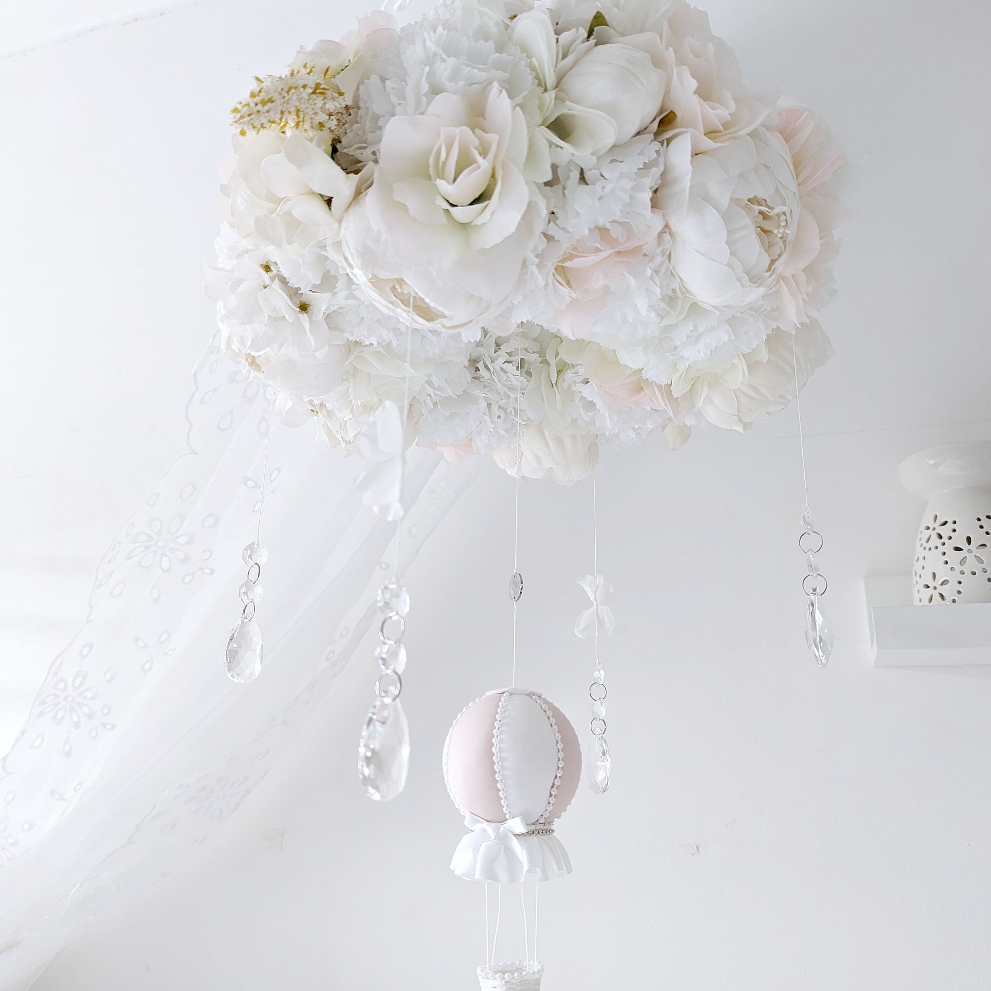 Hanging baby mobile with crystal accents, handcrafted florals, and a single blush balloon—luxury nursery decor.