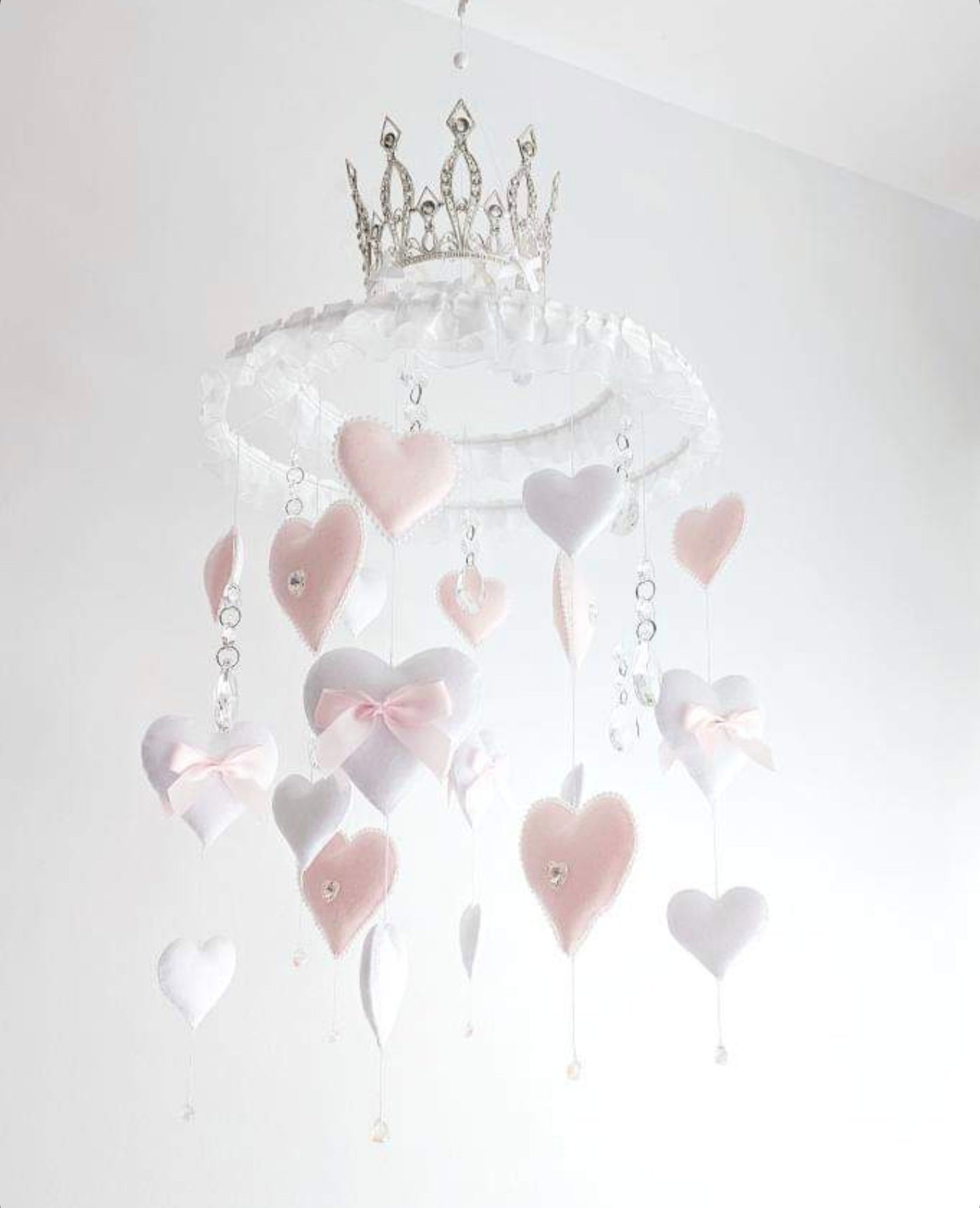 Luxury baby mobile with soft blush and white hearts, crystal accents, and a glittering crown on top.