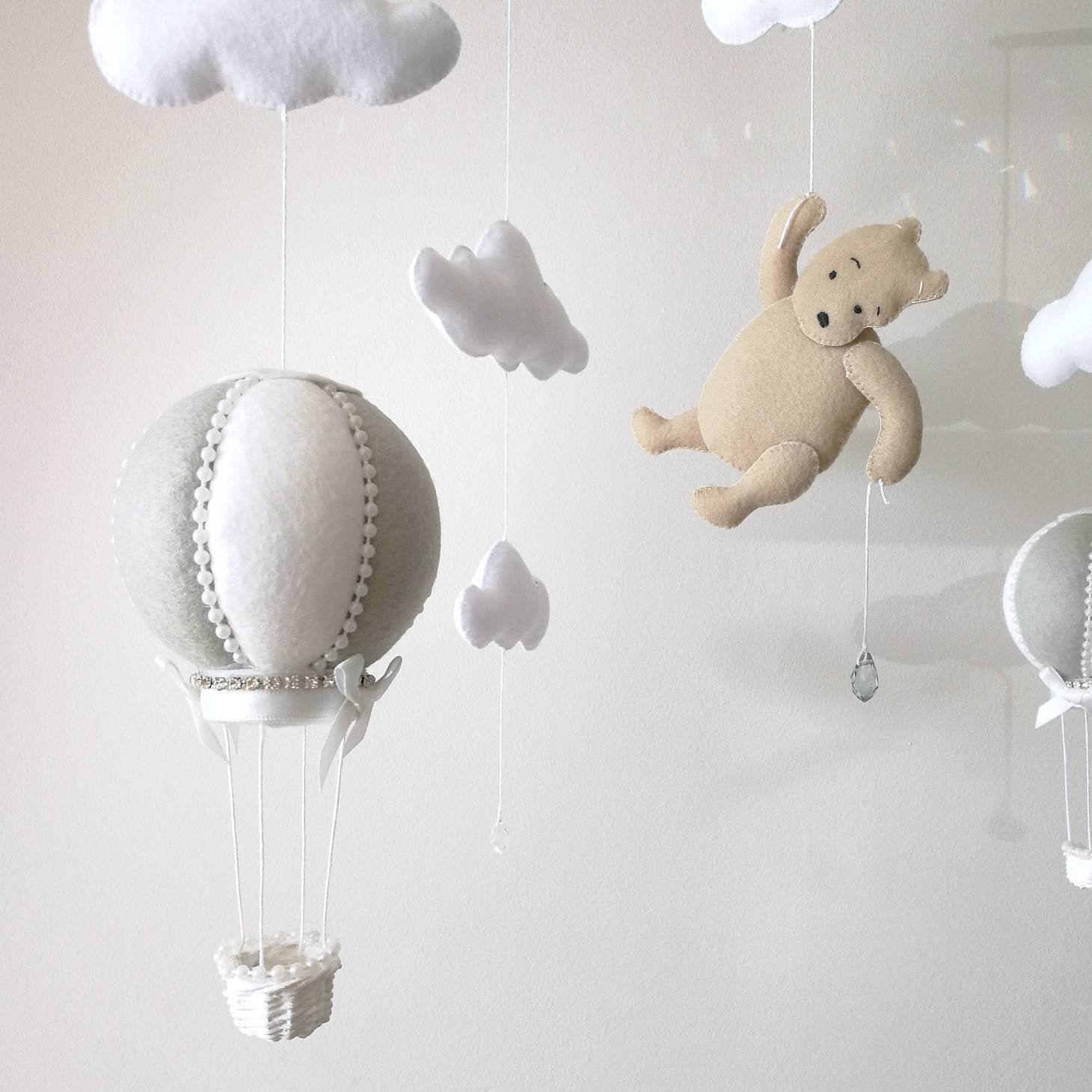 White felt clouds and delicate crystal drops bring light and softness to a lovingly handcrafted baby mobile

