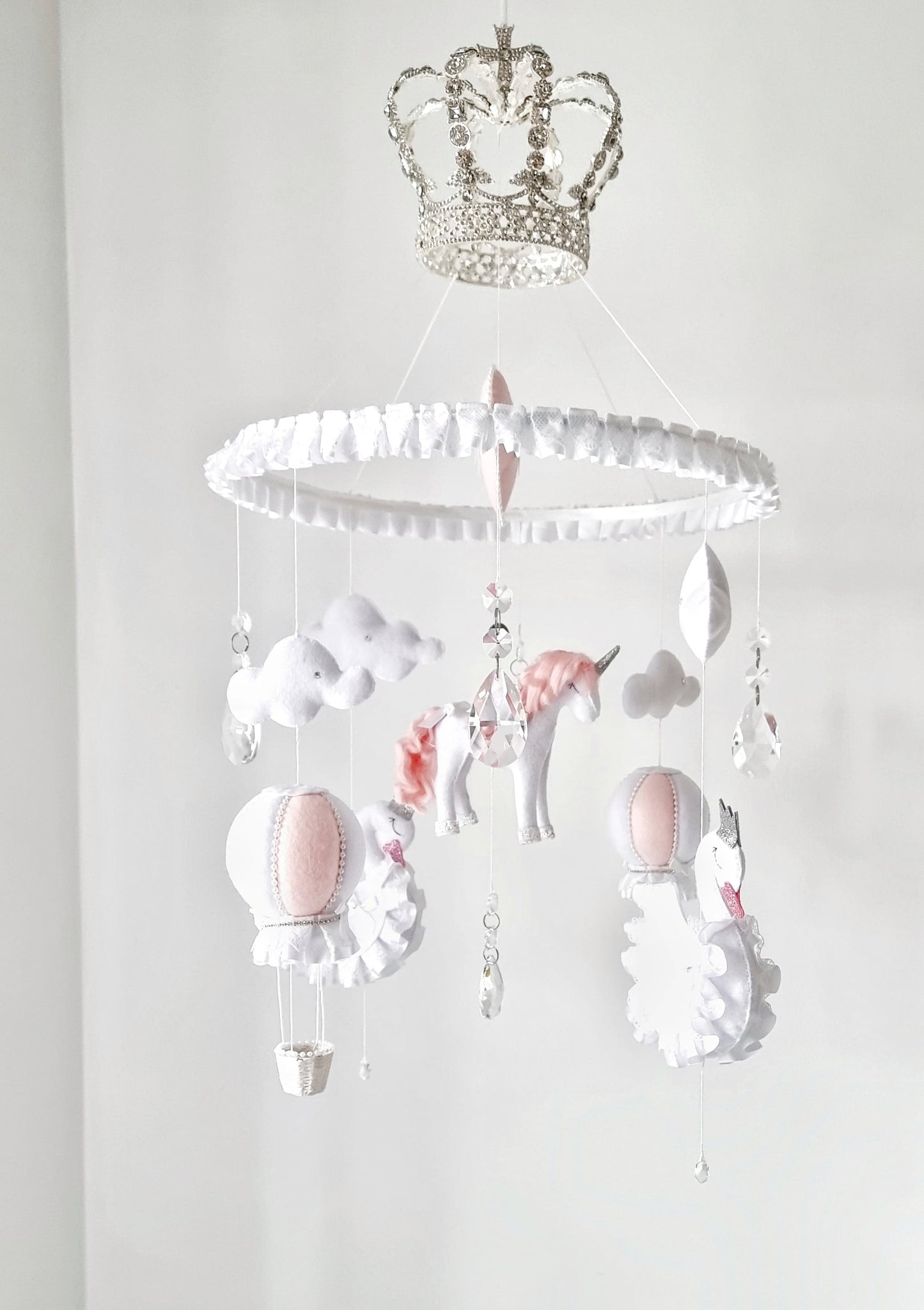 Luxury baby mobile with a sparkling crown, hand-stitched unicorn, and soft clouds, designed for a fairy tale-inspired nursery.

