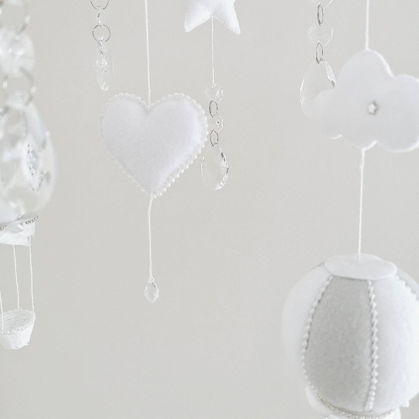 Neutral handmade nursery mobile with soft clouds, star accents, and a name embroidery for a timeless baby gift.

