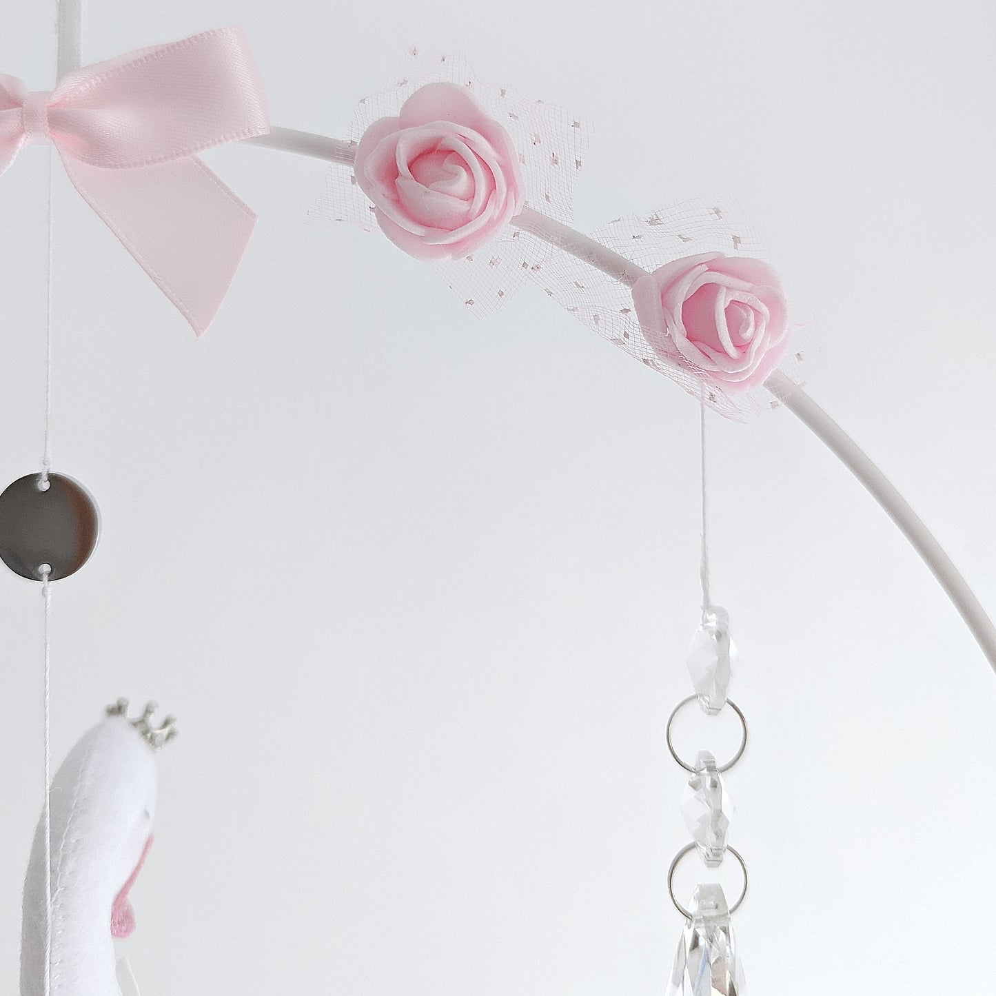 One-of-a-kind swan mobile with soft pastels and signature rose details, designed for a refined nursery.