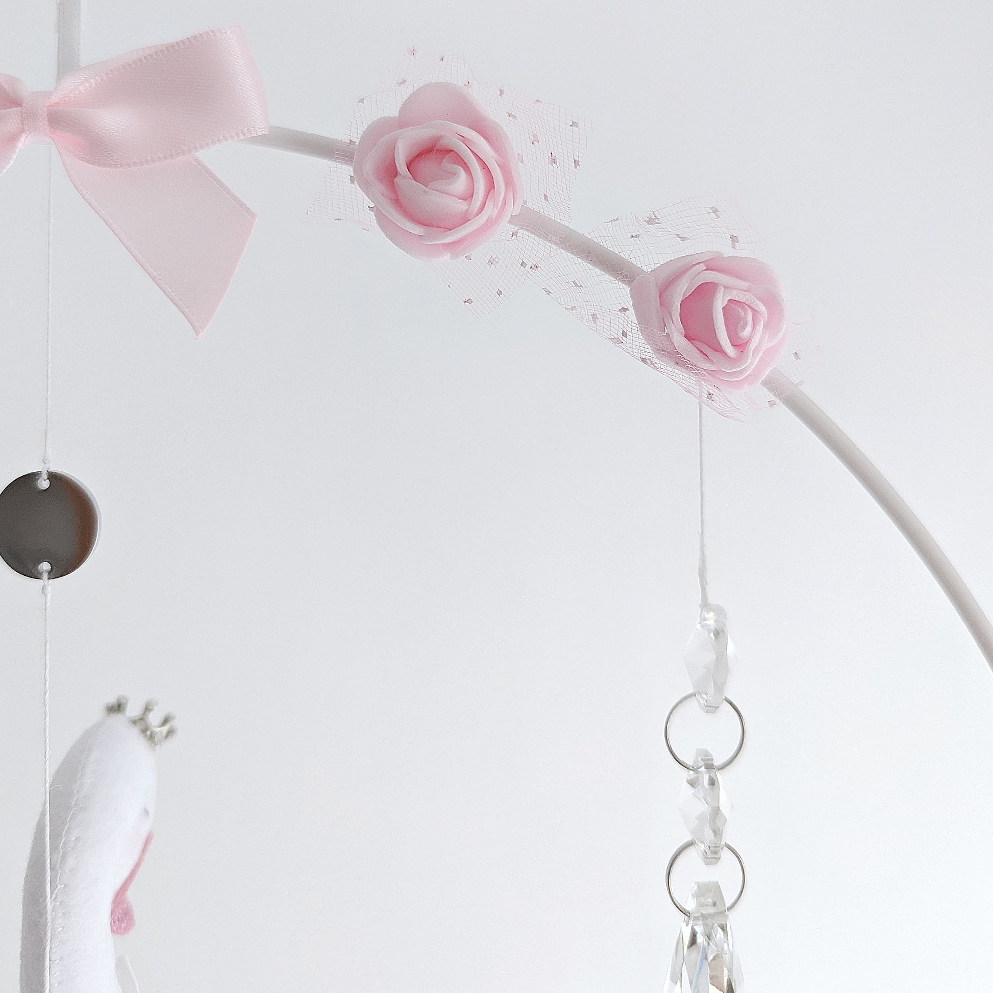 One-of-a-kind swan mobile with soft pastels and signature rose details, designed for a refined nursery.