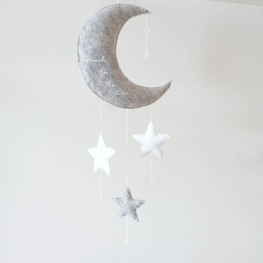 Grey crescent moon wall charm with “Reach for the stars” embroidery and stars—perfect as a baby shower or christening gift.

