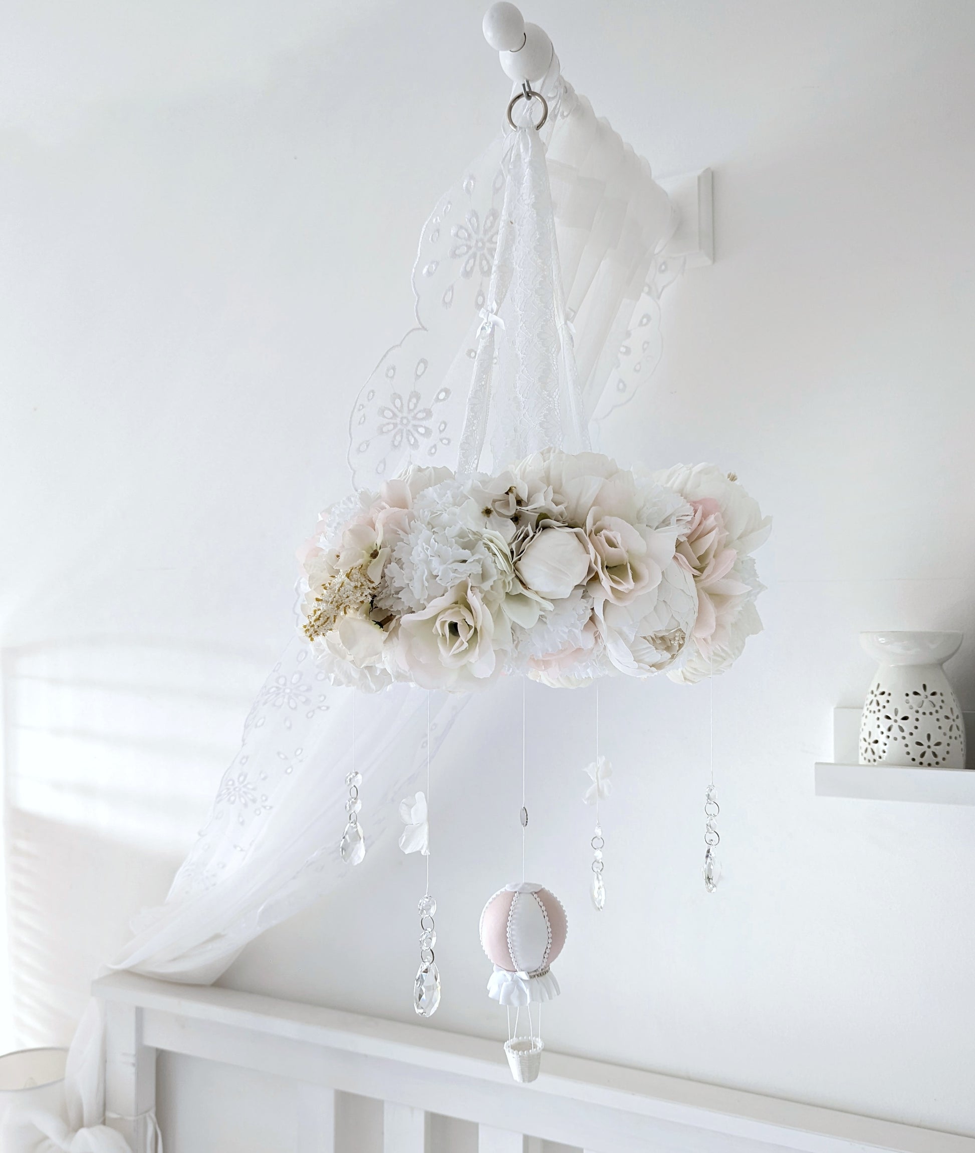 Romantic handmade mobile with ivory and blush faux florals, crystal drops, and a pink balloon for a luxury nursery.

