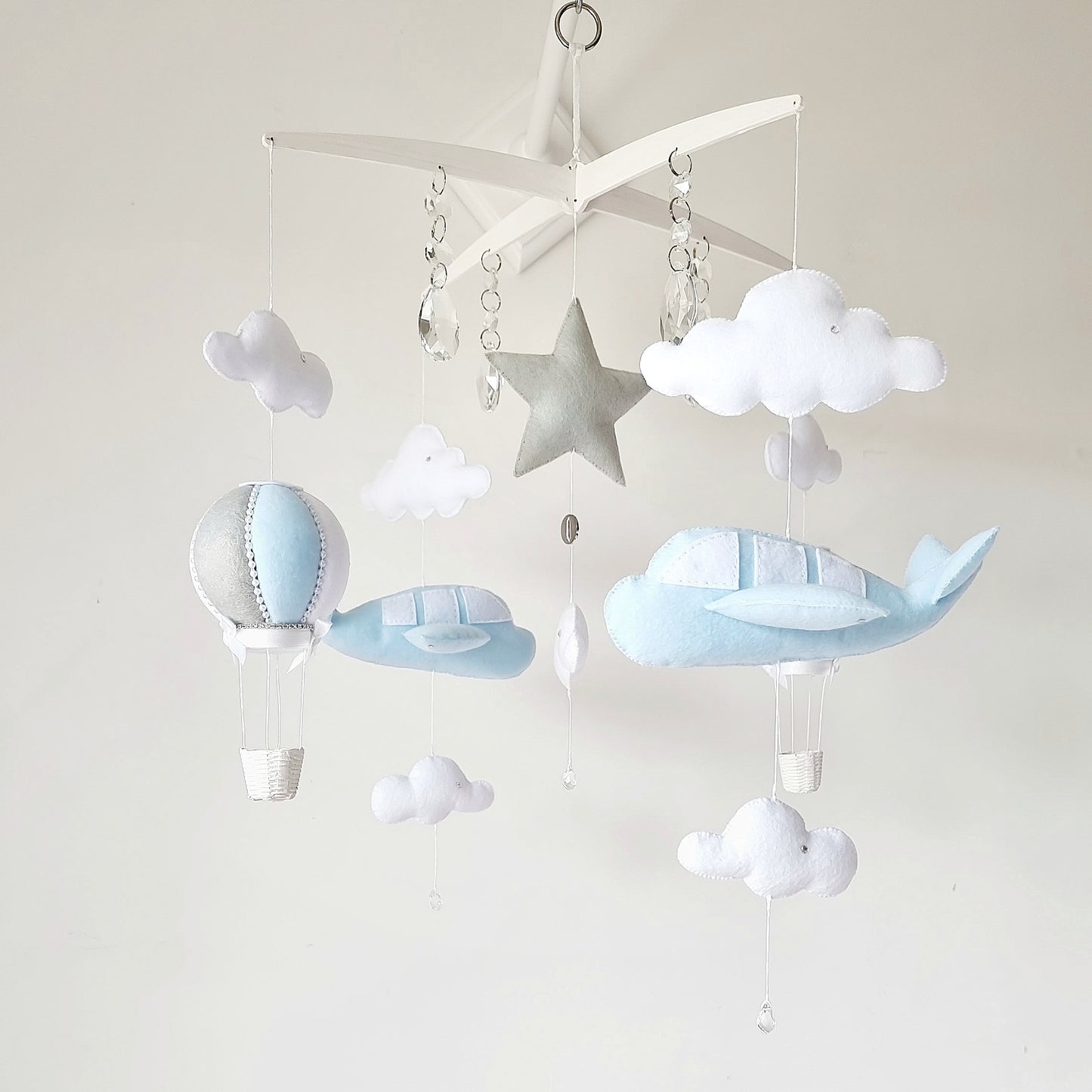 Sky-themed baby mobile featuring airplanes, fluffy clouds, and a silver star on a unique cross-style hanger.