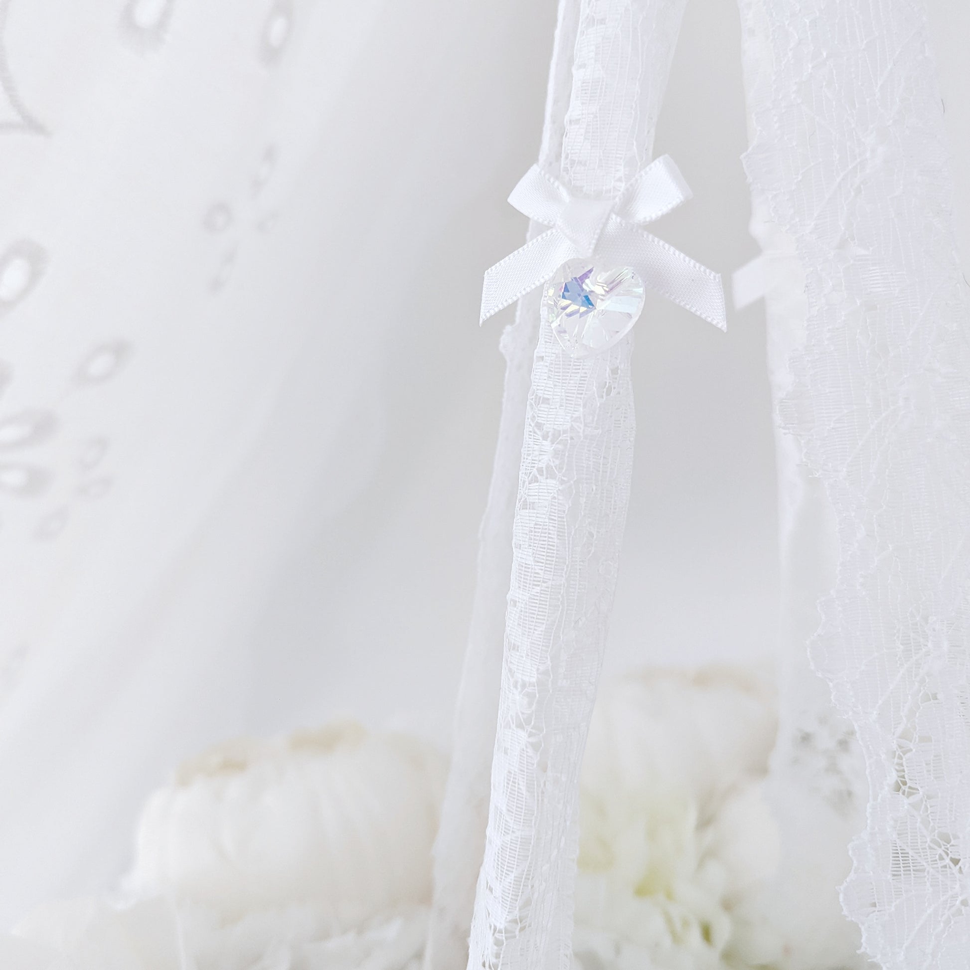 Close-up of soft blush and ivory florals forming a delicate wreath, part of a high-end baby mobile.

