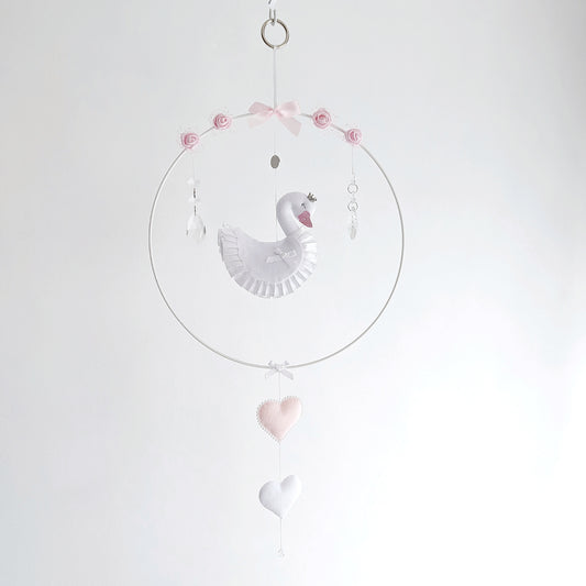 Luxury swan wall charm for baby girl nursery, featuring soft white felt swan with pink crown, crystal droplets, and delicate hanging hearts, handmade keepsake in soft blush and white.

