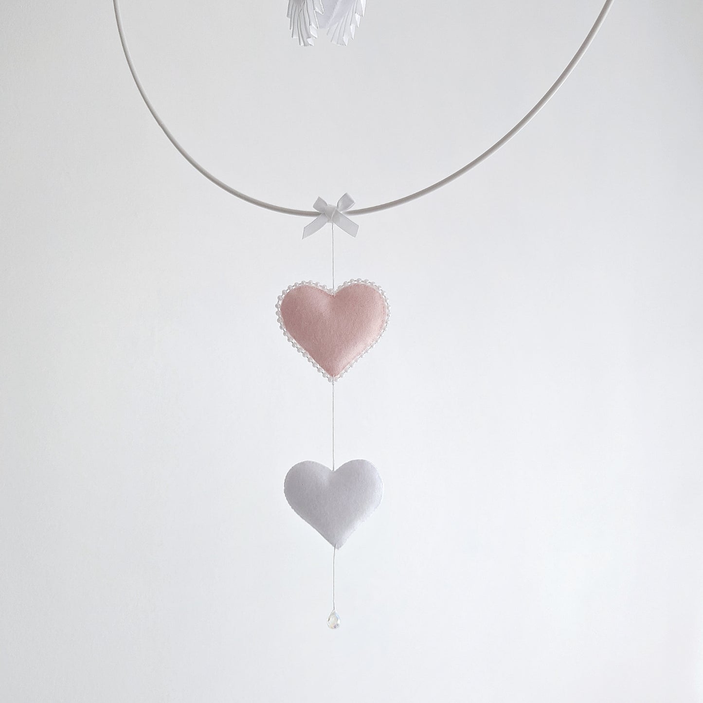 Timeless swan mobile design with layered feathers and gold crown, paired with blush hearts and a balloon.