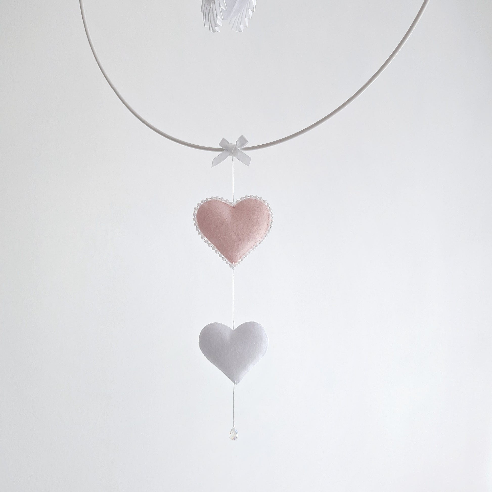 Timeless swan mobile design with layered feathers and gold crown, paired with blush hearts and a balloon.